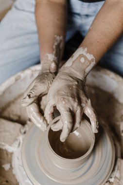 Kadın elleri kilden yemek yapar.