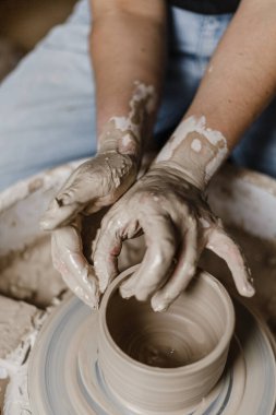 Kadın elleri kilden yemek yapar.
