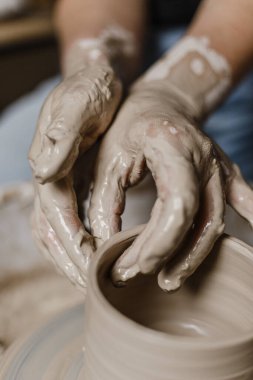 Kadın elleri kilden yemek yapar.