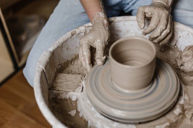 Kadın elleri kilden yemek yapar.