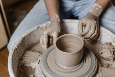 Kadın elleri kilden yemek yapar.