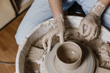 Kadın elleri kilden yemek yapar.