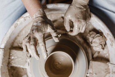 Kadın elleri kilden yemek yapar.