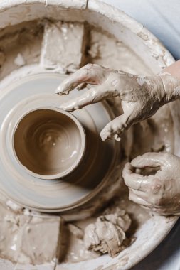 Kadın elleri kilden yemek yapar.