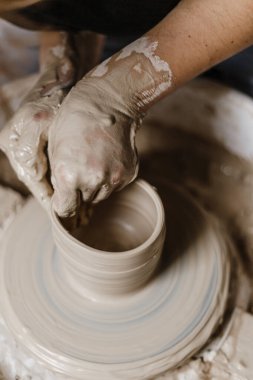 Kadın elleri kilden yemek yapar.