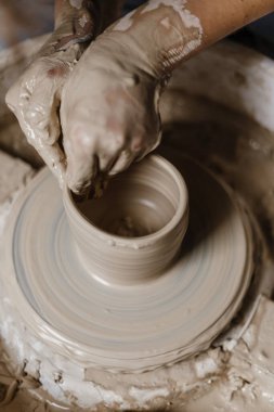 Kadın elleri kilden yemek yapar.