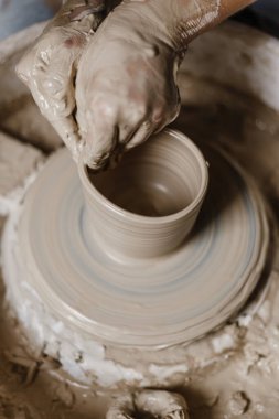 Kadın elleri kilden yemek yapar.