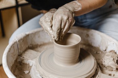 Kadın elleri kilden yemek yapar.