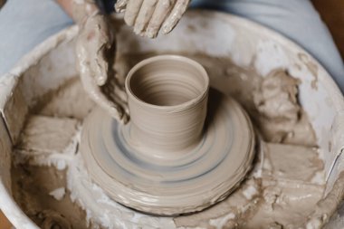 Kadın elleri kilden yemek yapar.