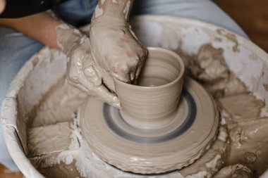 Kadın elleri kilden yemek yapar.