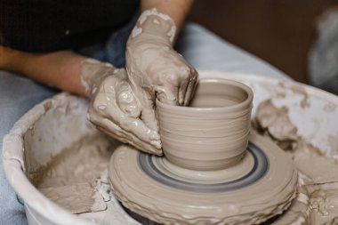 Kadın elleri kilden yemek yapar.