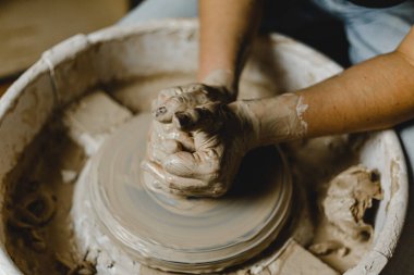 Kadın elleri kil tabaklarını şekillendirir.