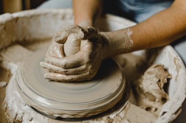 Kadın elleri kil tabaklarını şekillendirir.