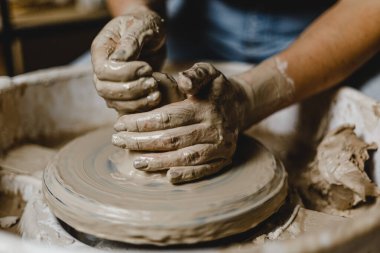 Kadın elleri kil tabaklarını şekillendirir.