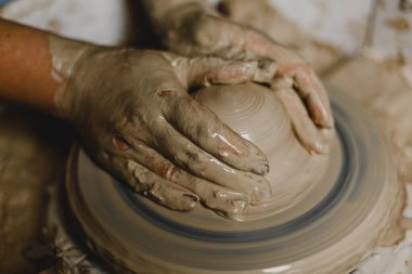 Kadın elleri kil tabaklarını şekillendirir.