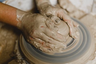 Kadın elleri kil tabaklarını şekillendirir.