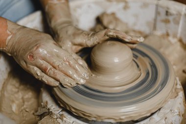 Kadın elleri kil tabaklarını şekillendirir.