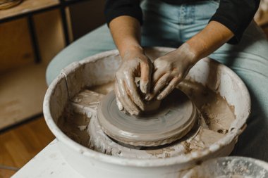 Kadın elleri kil tabaklarını şekillendirir.