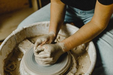 Kadın elleri kil tabaklarını şekillendirir.