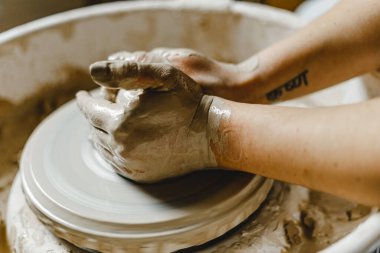 Kadın elleri kil tabaklarını şekillendirir.