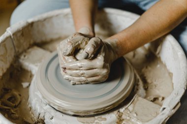 Kadın elleri kil tabaklarını şekillendirir.