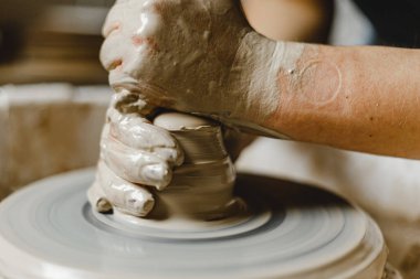 Kadın elleri kil tabaklarını şekillendirir.