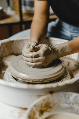 Kadın elleri kil tabaklarını şekillendirir.