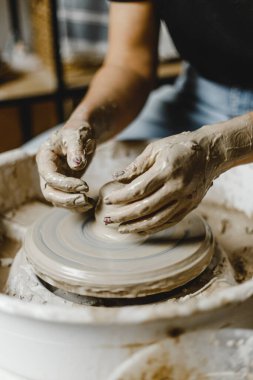Kadın elleri kil tabaklarını şekillendirir.