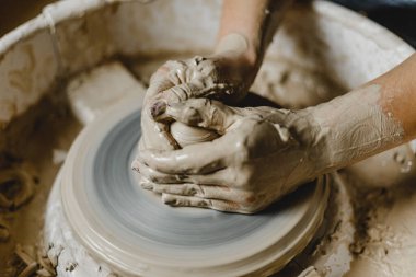 Kadın elleri kil tabaklarını şekillendirir.