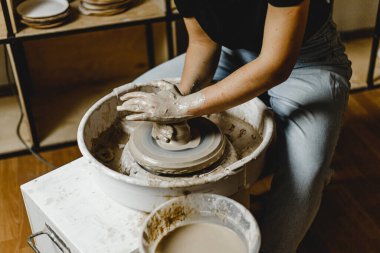 Kadın elleri kil tabaklarını şekillendirir.