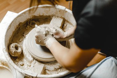 Kadın elleri kil tabaklarını şekillendirir.