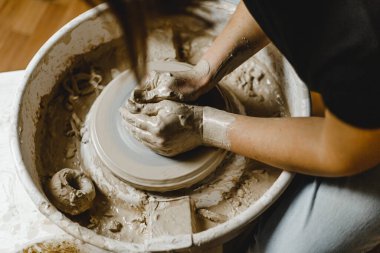 Kadın elleri kil tabaklarını şekillendirir.