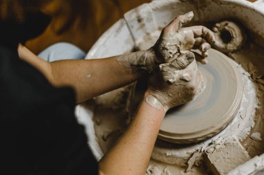 Kadın elleri kil tabaklarını şekillendirir.