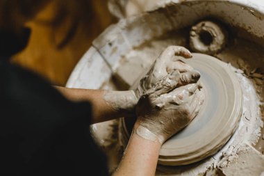 Kadın elleri kil tabaklarını şekillendirir.