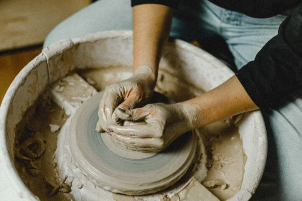 Kadın elleri kil tabaklarını şekillendirir.