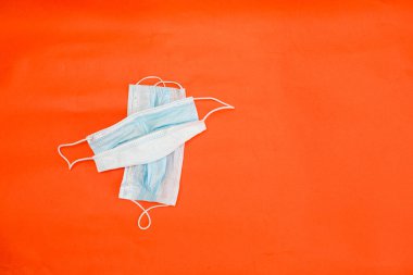 Koronavirüsten koruyucu maskeler kırmızı arkaplanda yatar