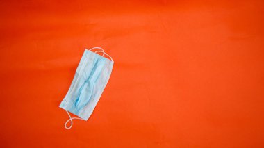 Koronavirüsten koruyucu maskeler kırmızı arkaplanda yatar