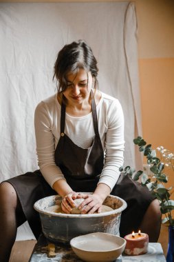 Potter kızı çömlekçi çarkında kilden kupa yontuyor. Öğleden sonra çömlek atölyesi