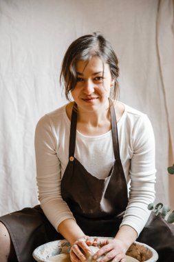 Potter kızı çömlekçi çarkında kilden kupa yontuyor. Öğleden sonra çömlek atölyesi