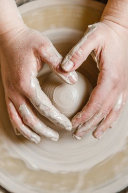 Potter kızı çömlekçi çarkında kilden kupa yontuyor. Öğleden sonra çömlek atölyesi