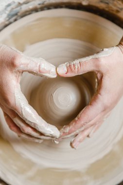 Potter kızı çömlekçi çarkında kilden kupa yontuyor. Öğleden sonra çömlek atölyesi