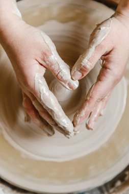 Potter kızı çömlekçi çarkında kilden kupa yontuyor. Öğleden sonra çömlek atölyesi