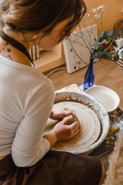 Potter kızı çömlekçi çarkında kilden kupa yontuyor. Öğleden sonra çömlek atölyesi