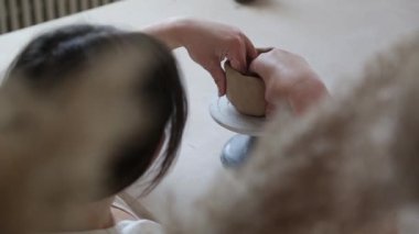 Kadın seramikçi elleri kil tabakları yontuyor