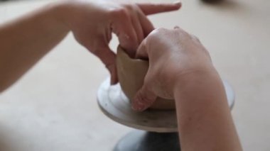 Kadın seramikçi elleri kil tabakları yontuyor