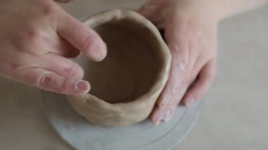 Kadın seramikçi elleri kil tabakları yontuyor