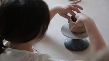 Kadın seramikçi elleri kil tabakları yontuyor