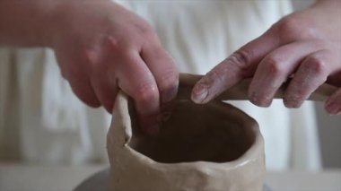 Kadın seramikçi elleri kil tabakları yontuyor