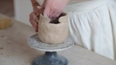 Kadın seramikçi elleri kil tabakları yontuyor