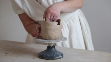 Kadın seramikçi elleri kil tabakları yontuyor